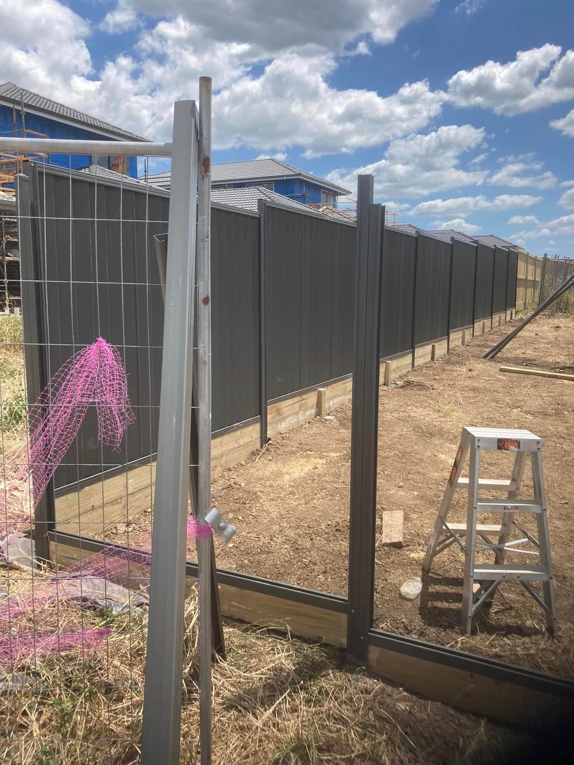 A charcoal Colorbond boundary fence at a new build site