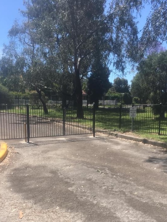 A black tubular gate and fence at a reserve entrance